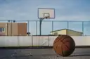 A basketball resting on an outdoor court