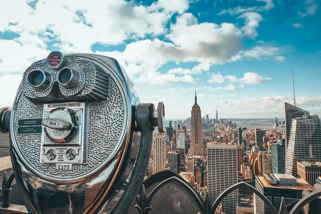 Coin binoculars on an observation deck looking out at the Empire State Building and Manhattan