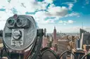 Coin binoculars on an observation deck looking out at the Empire State Building and Manhattan