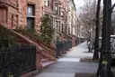 A Brooklyn sidewalk lined with brownstones