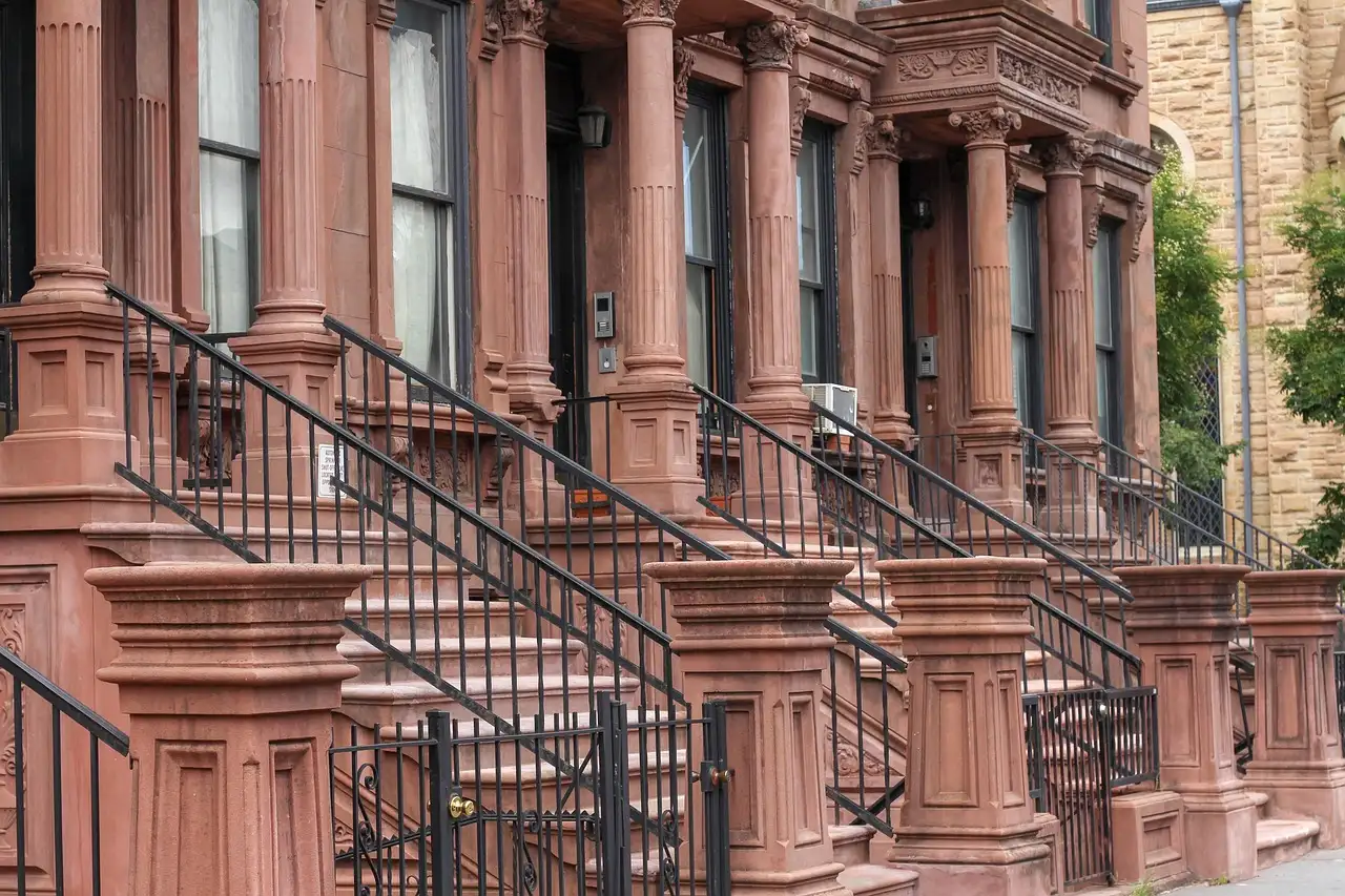 A row of brownstone houses with tall stone stoops