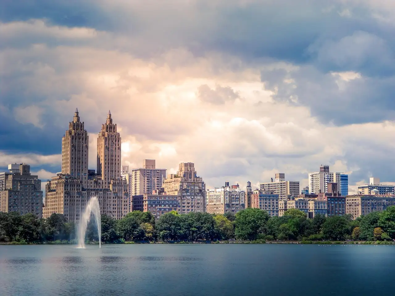 The Central Park reservoir fountain with Upper West Side towers behind