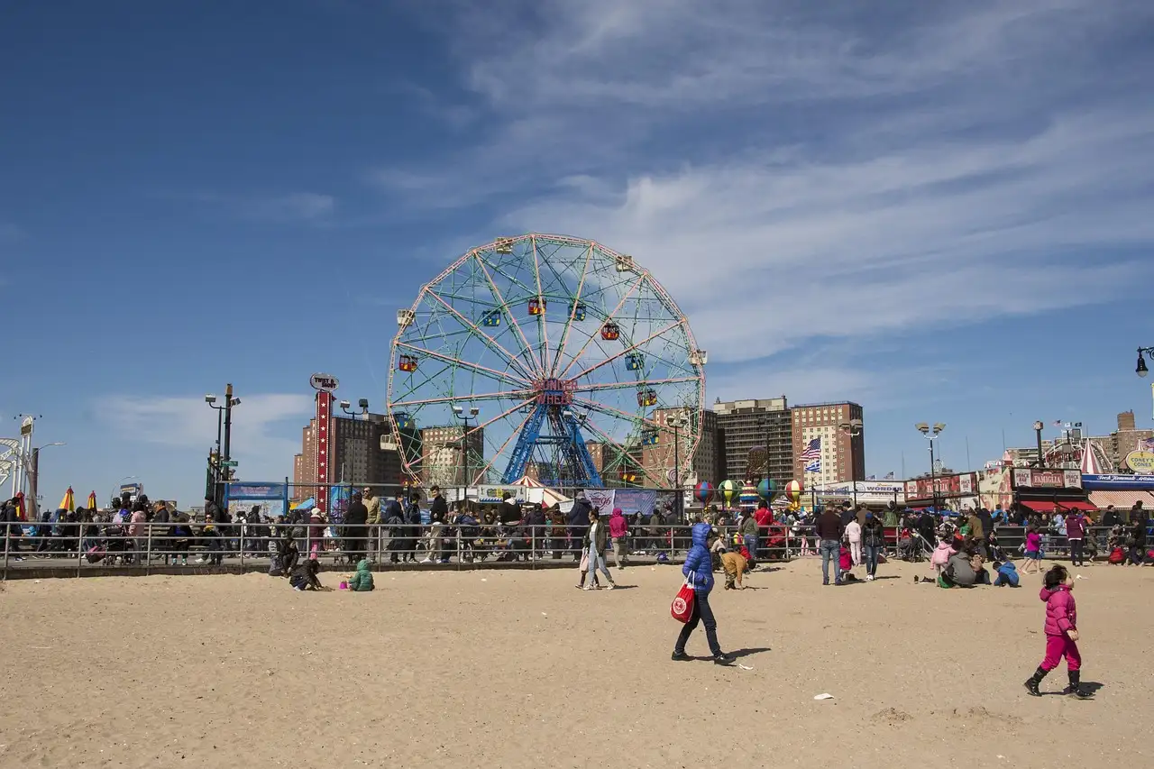 The Wonder Wheel and the Coney Island boardwalk seen from the beach on a sunny day