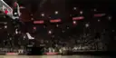 A player dunking in a darkened arena