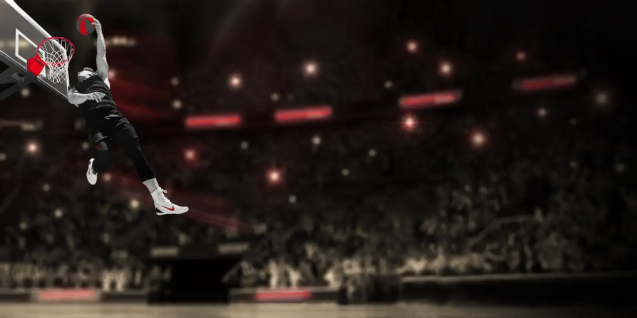 A player dunking in a darkened arena