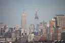 The Empire State Building above the skyline, seen from across the river