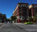 A Harlem street corner with brick apartment buildings