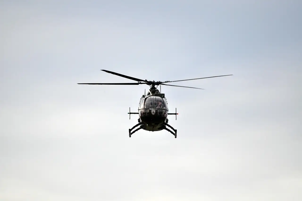 A helicopter flying under clouds