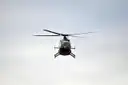 A helicopter flying under clouds