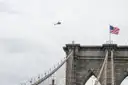 A helicopter flying over the Brooklyn Bridge