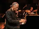 A jazz pianist and drummer on stage