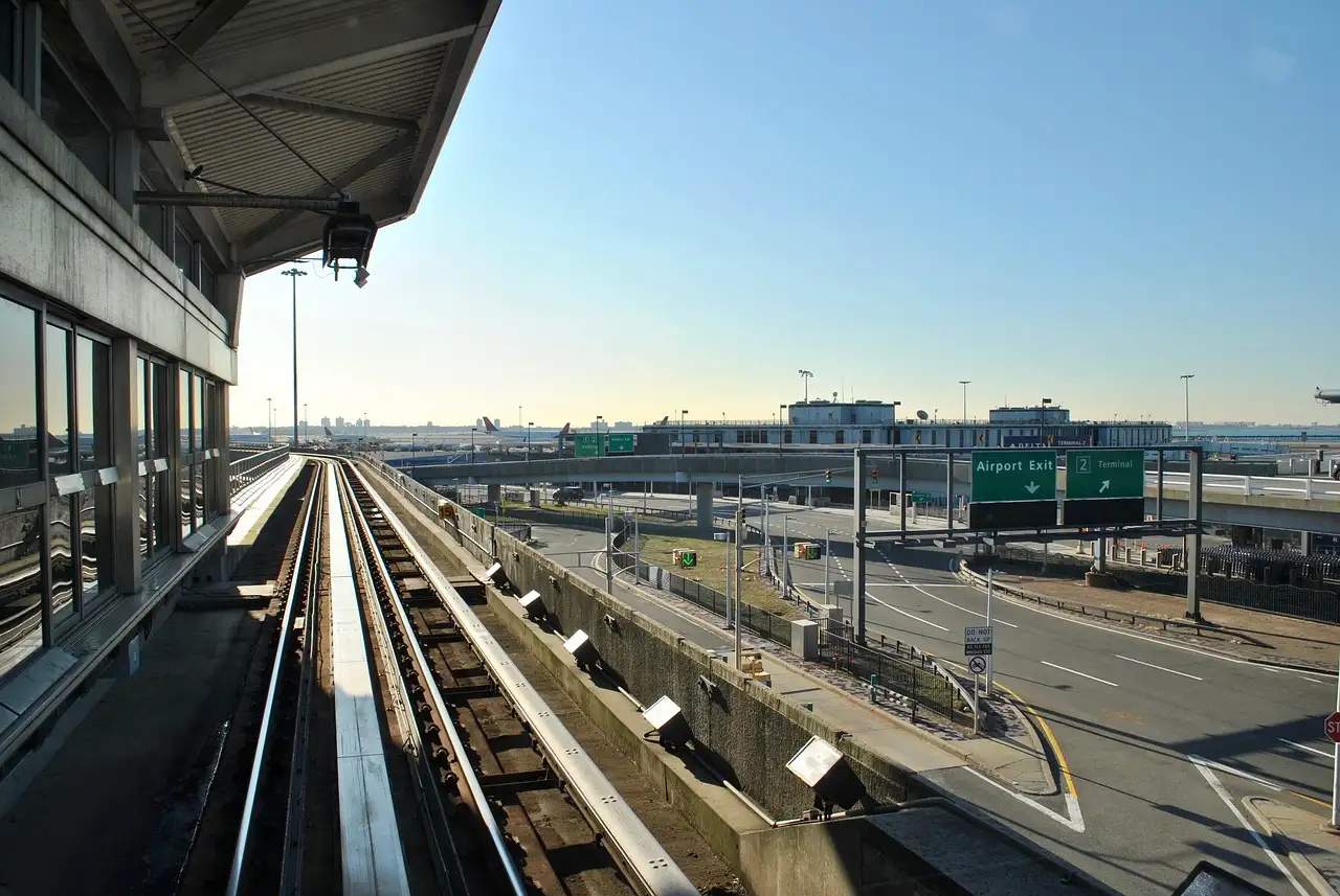 The AirTrain JFK track running past a terminal at JFK Airport on a clear evening