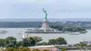Liberty Island with boats passing in the harbour