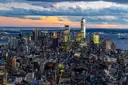 Lower Manhattan from above at dusk, with One World Trade Center and the harbour behind