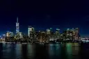 Lower Manhattan lit at night across the water