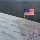 A small US flag in the names on the memorial