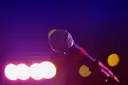 A microphone against purple stage lights