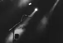 A microphone stand in a spotlight, in black and white