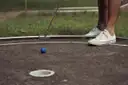 A putter and a blue ball on a mini-golf course