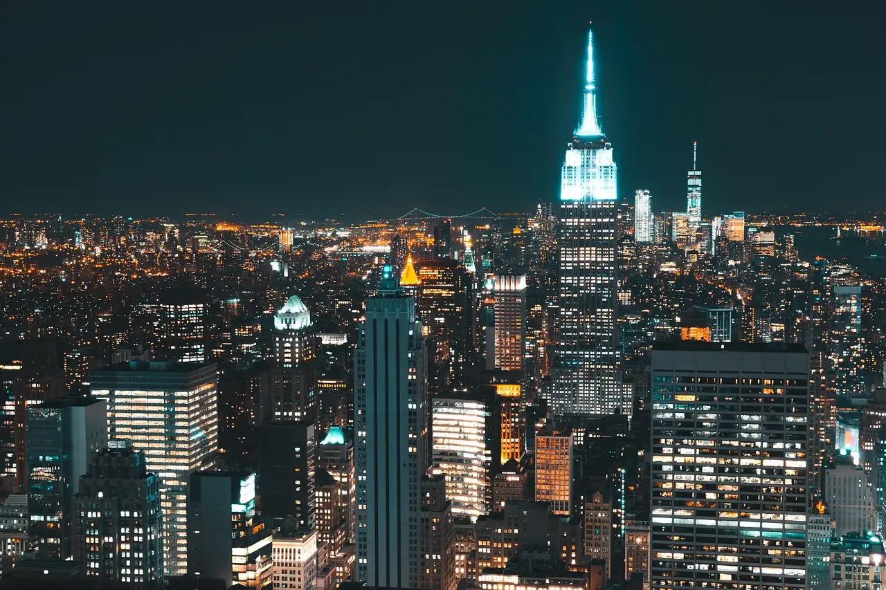 Midtown Manhattan at night from above, with the Empire State Building lit up