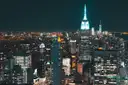 Midtown Manhattan at night from above, with the Empire State Building lit up