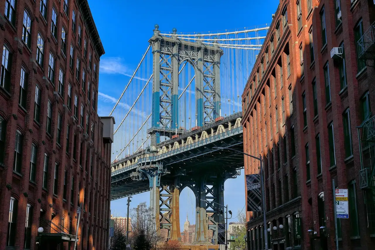 The Manhattan Bridge framed by red-brick warehouse buildings on Washington Street in DUMBO, Brooklyn