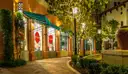 Open-air outlet shops with sale signs along a lit walkway