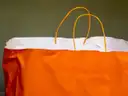 An orange paper shopping bag