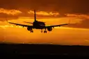 A plane landing at sunset