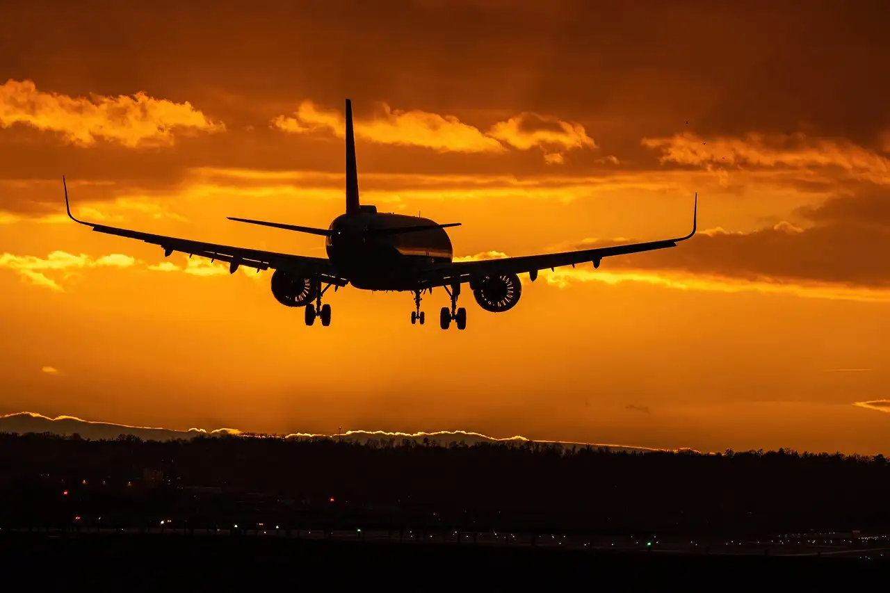 A plane landing at sunset