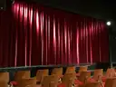 A red stage curtain lit by a spotlight