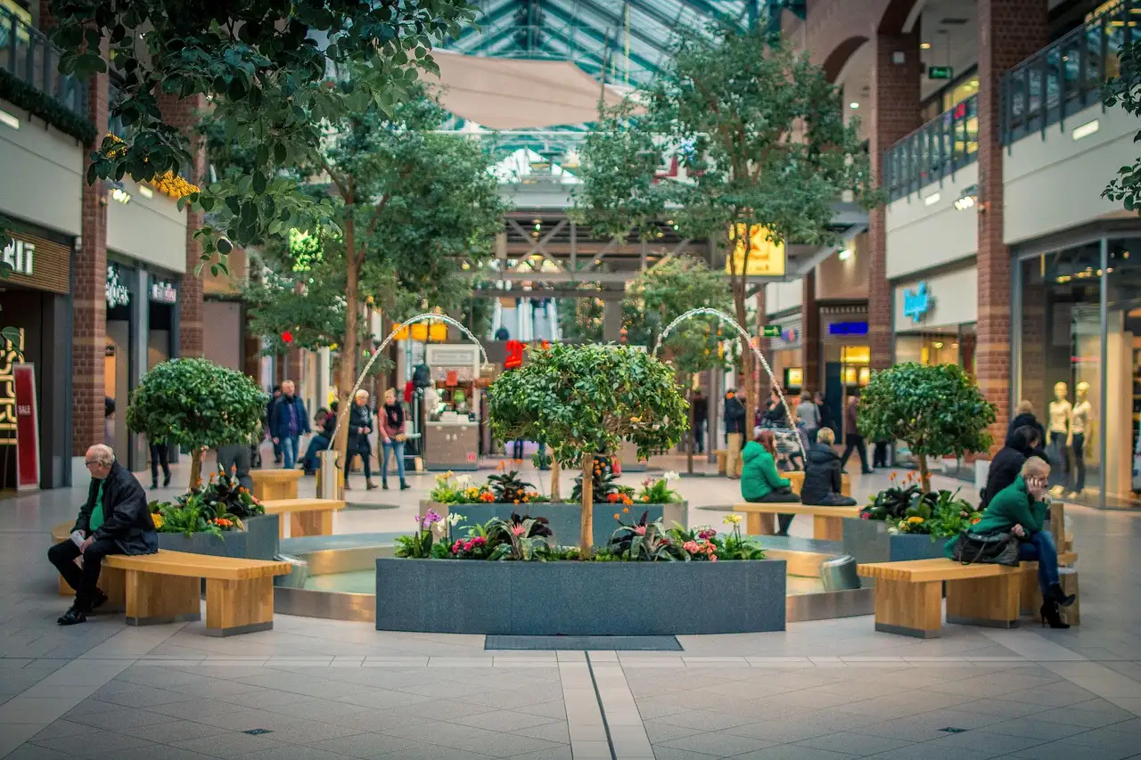 A shopping mall square with trees and benches