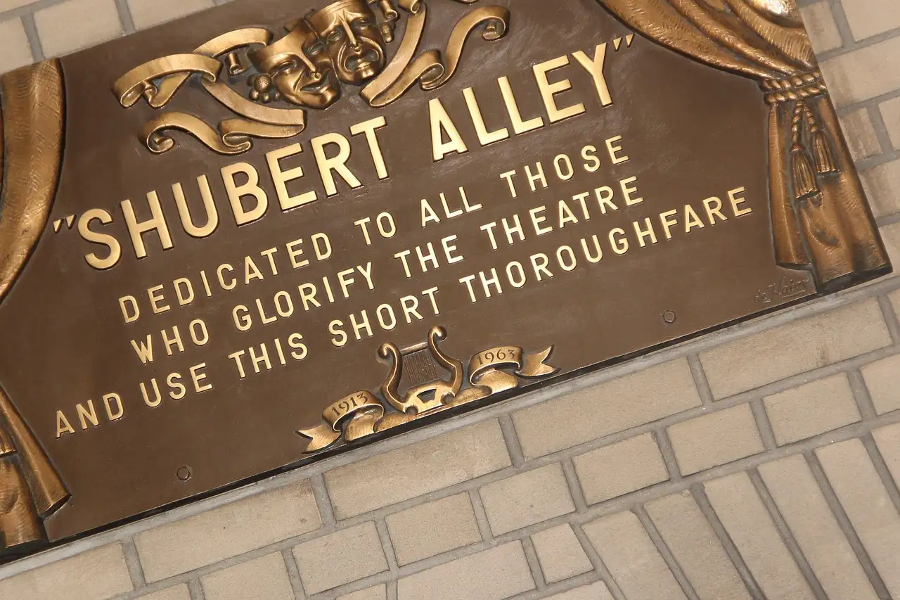 The bronze Shubert Alley plaque in the Theater District, dedicated to all who glorify the theatre