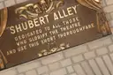 The bronze Shubert Alley plaque in the Theater District, dedicated to all who glorify the theatre