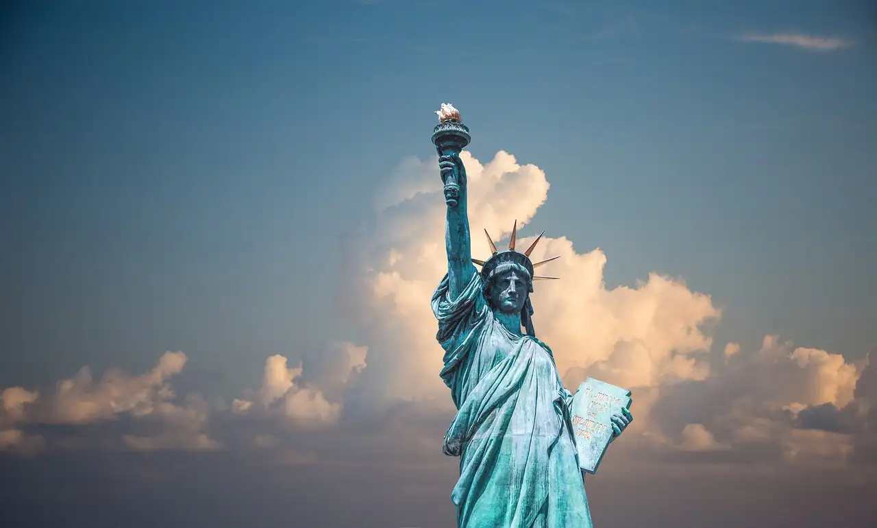The Statue of Liberty against white clouds and blue sky