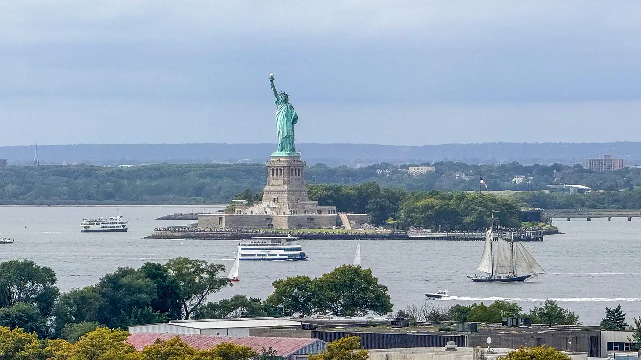 The Statue of Liberty with a sailing ship passing