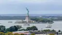 The Statue of Liberty with a sailing ship passing