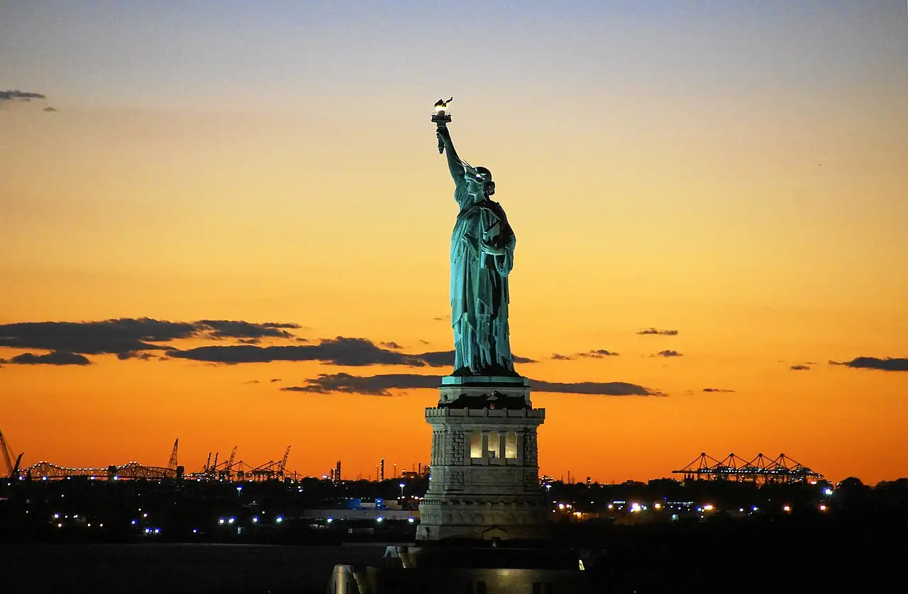 The Statue of Liberty against an orange sunset
