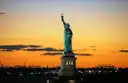 The Statue of Liberty against an orange sunset