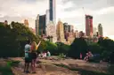 A couple standing on a rock in Central Park, looking at the Midtown skyline