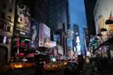 Times Square at dusk with the screens lit and taxis in the street