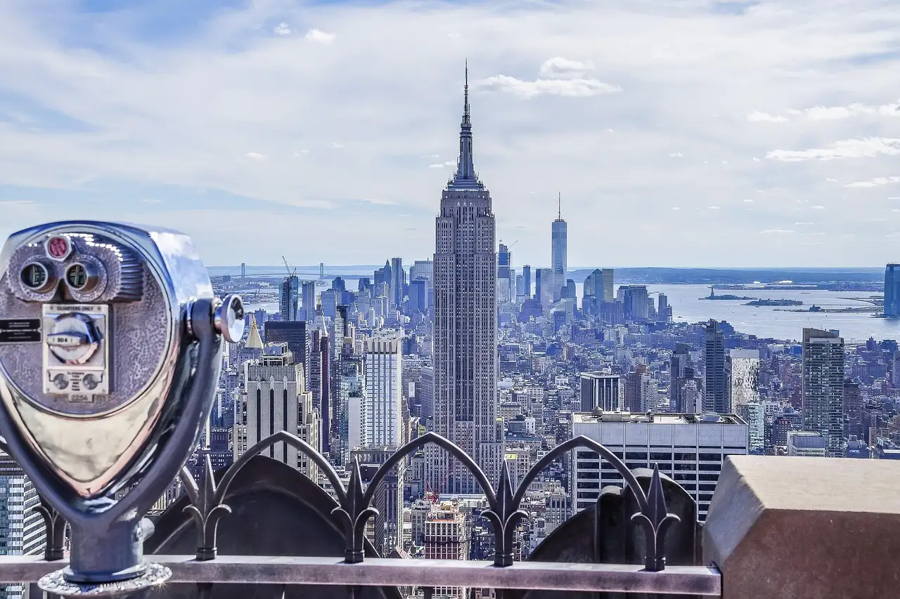 A coin-operated viewer on an observation deck, with the Empire State Building beyond