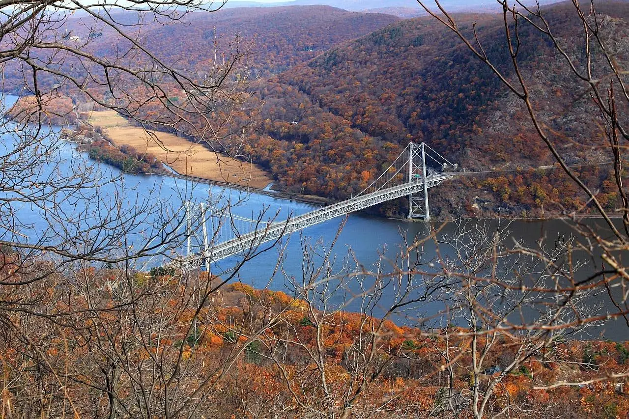A suspension bridge over the Hudson River in the Hudson Valley, with hills in autumn colors
