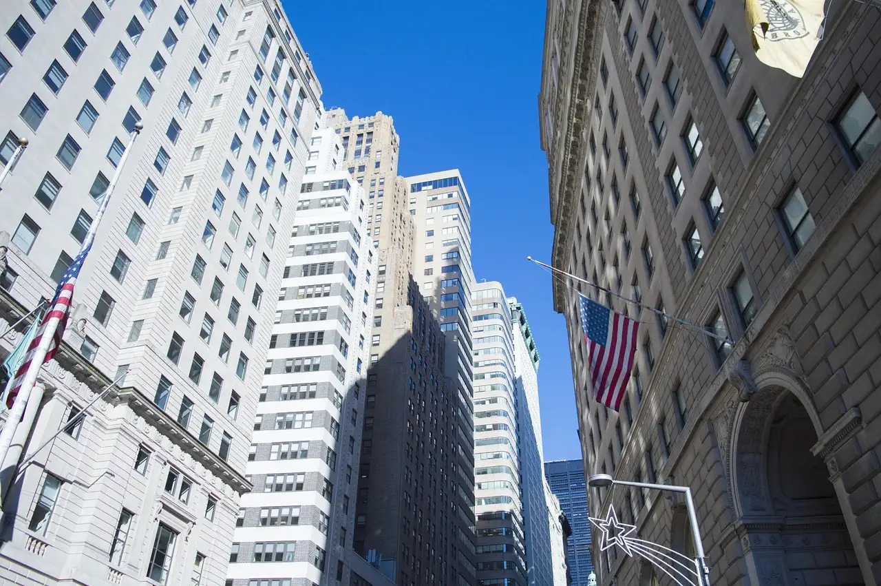 Wall Street between tall buildings with US flags